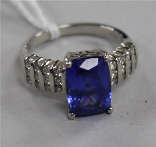 A modern platinum, tanzanite and diamond set dress ring, size O.